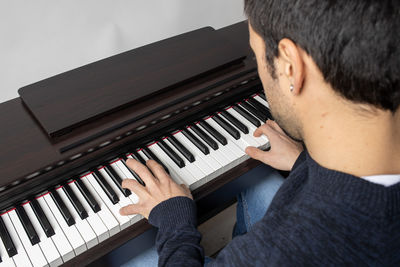 Low section of man playing piano