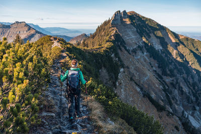 Woman hiking on footpath in alpine landscape in autumn, osterhorn mountain range, salzburg, austria