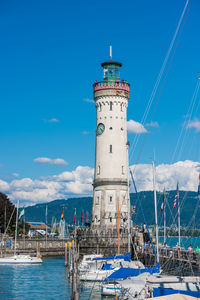 Lighthouse by sea against sky