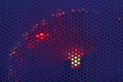 Full frame shot of illuminated red metal grate