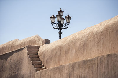 Low angle view of street light against building and streetlight