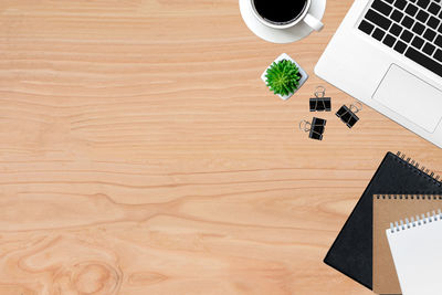 High angle view of coffee cup and office supplies with smart phone on table