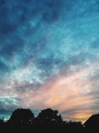 Silhouette of trees against cloudy sky