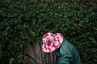 Midsection of person standing by pink tree against plants