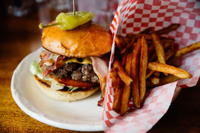 Close-up of burger and french fries in plate on table