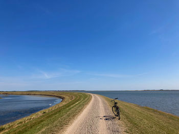 Road by sea against sky