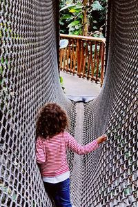 Rear view of girl playing in jungle gym