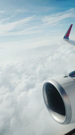 Airplane flying over cloudscape against sky