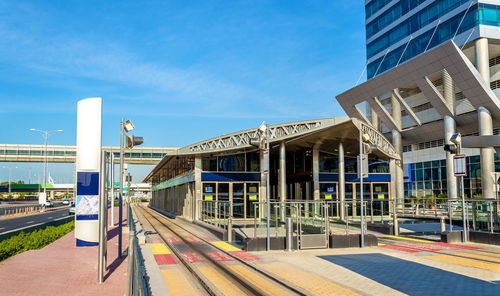 View of railroad station by buildings against sky