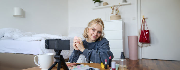 Side view of young woman using mobile phone while sitting at home