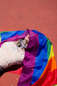 Young woman with rainbow flag lying down