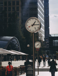 People on street amidst buildings in city