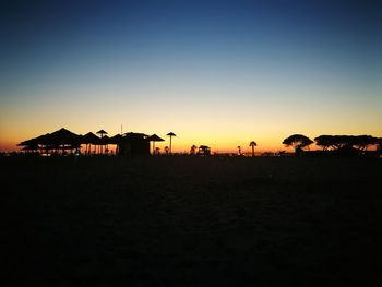 Silhouette built structures against clear sky