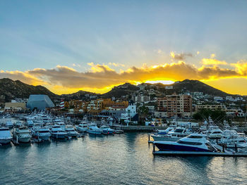 Sailboats in city at sunset