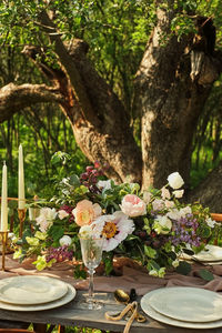 Flower vase on table against trees