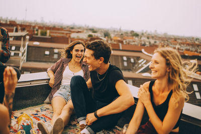 Happy young couple sitting in city