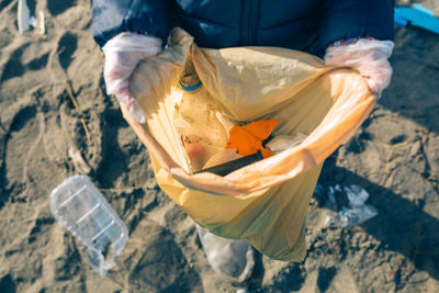 Low section of person collecting garbage