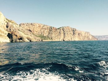 Scenic view of rocks in sea against clear sky