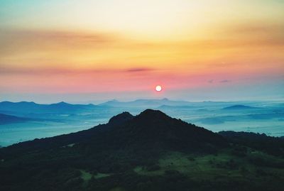 Scenic view of silhouette mountains against sky at sunset