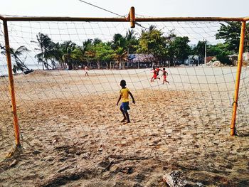 Boy playing on field against sky