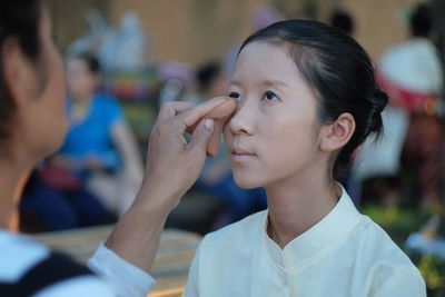 Artist applying make-up to girl