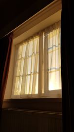 Low angle view of sunlight streaming through window in house