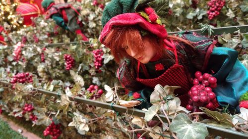 Midsection of woman holding red berries on plant