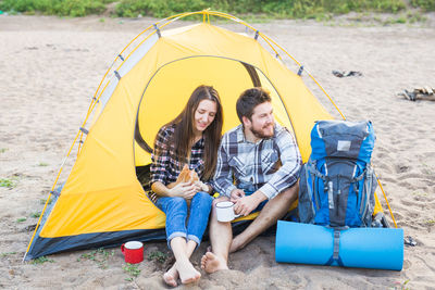 Young couple sitting on tent