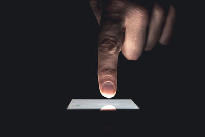 Close-up of hand holding black background