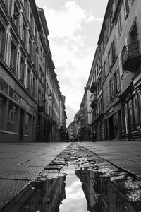 Puddle in city against sky