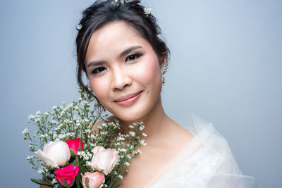 Portrait of young woman holding flower bouquet