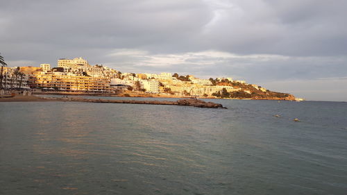 Scenic view of sea and buildings against sky