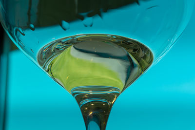 Close-up of beer glass on blue table