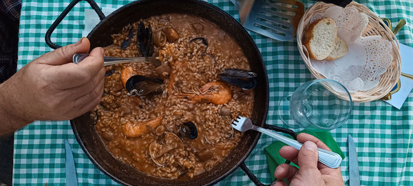 Friends eating rice paella with seafood. valencian tradition