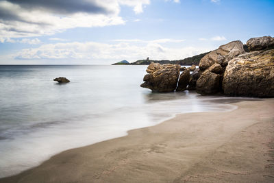 Scenic view of rocks in sea against sky