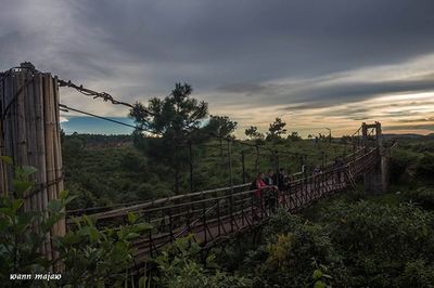 View of footbridge against cloudy sky