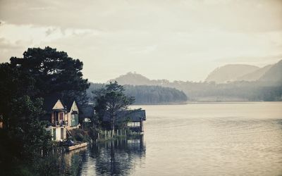 Scenic view of lake by building against sky