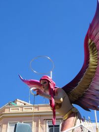 Low angle view of statue against clear blue sky