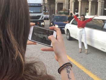 Rear view of woman photographing with mobile phone