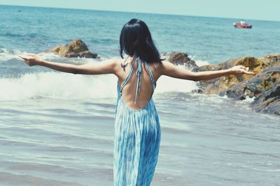 Rear view of woman standing in sea