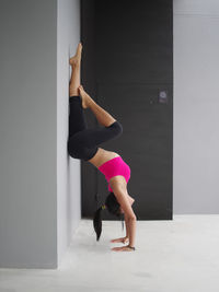 Full length of woman climbing on wall