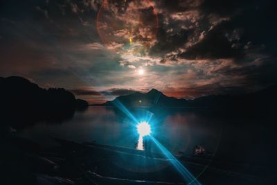 Scenic view of illuminated silhouette against sky during sunset