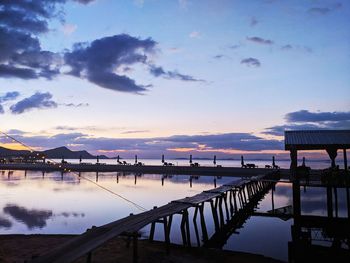 Pier over sea against sky during sunset