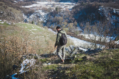 Full length of man standing on rock against trees