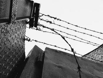 Low angle view of barbed wire against clear sky