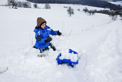 Full length of boy on snow covered field