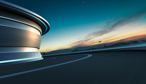 Low angle view of curvy road against sky during sunset