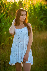 Portrait of young woman standing against plants