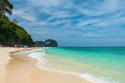 Tourist people walk on beach with turquoise andaman sea and blue sky at bamboo island