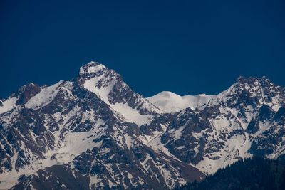 Scenic view of snowcapped mountains against clear blue sky